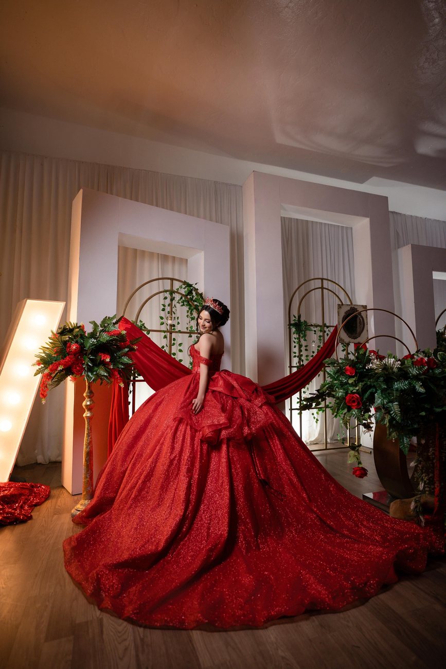 A quinceañera portrait framed by roses and marquee light