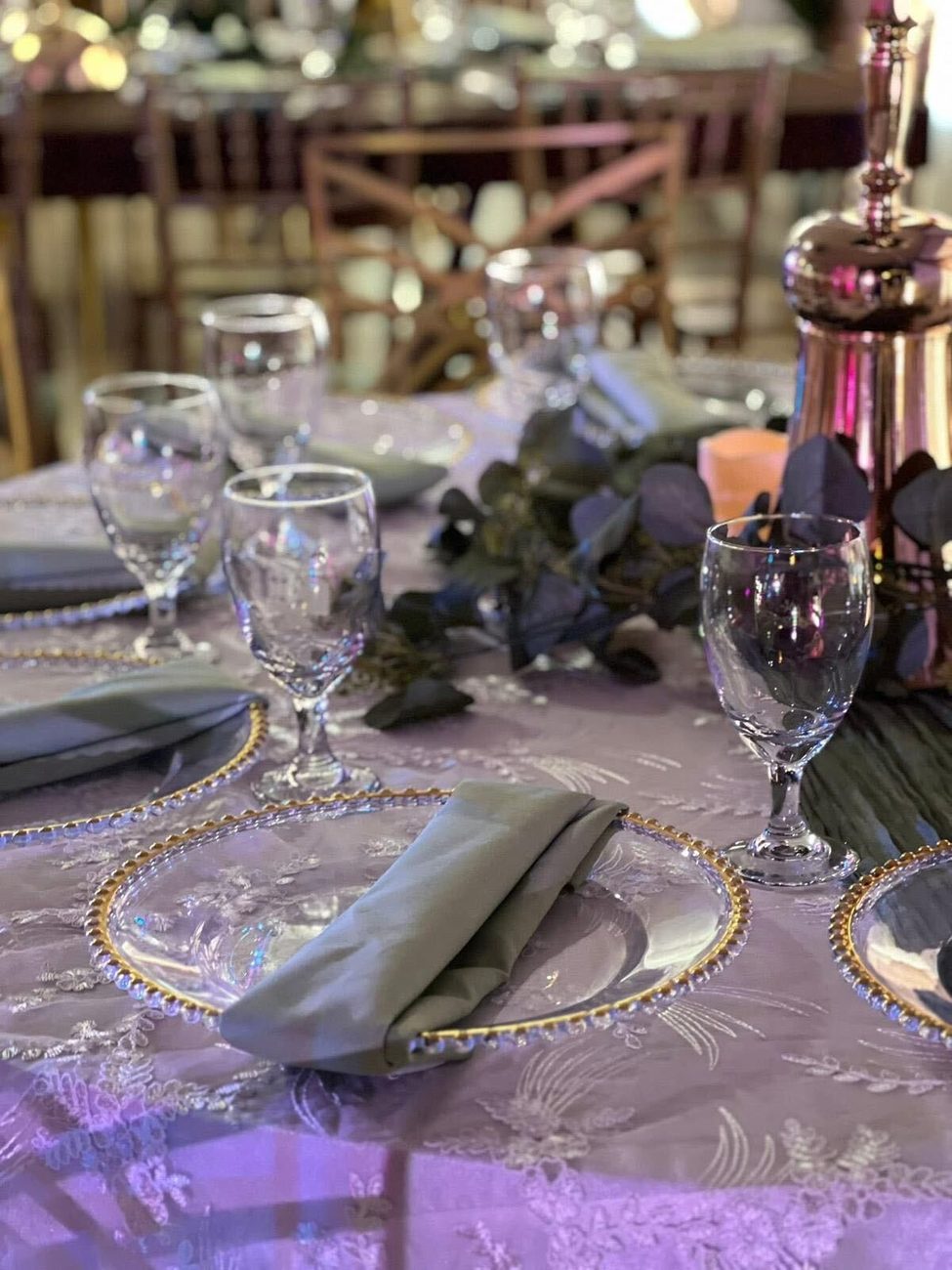 Beaded chargers and eucalyptus on a lilac table setting